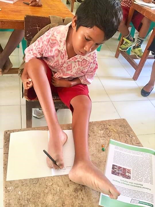 Owen saat menulis dengan kaki. (Ist)